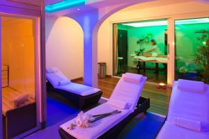 a room with white chairs and a table with a person in the background at Mangio Fango Hotel et Spa in Saintes-Maries-de-la-Mer