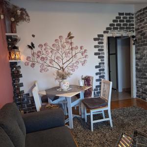 Mila في Kaštel Novi: غرفة طعام مع طاولة وكراسي وجدار من الطوب