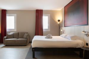 une chambre d'hôtel avec un lit et une chaise dans l'établissement ibis Douai Dechy, à Dechy