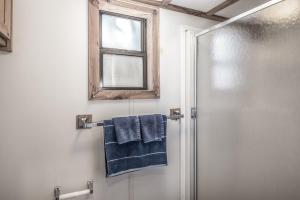 een badkamer met een douche en een blauwe handdoek bij Rainbow Lake Cabin & RV Resort in Ruidoso