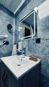 ein Badezimmer mit einem weißen Waschbecken und einem Spiegel in der Unterkunft El Baboos Hotel in Bostaniçi