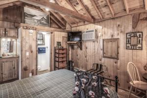 - une chambre avec un lit dans une pièce dotée de murs en bois dans l'établissement Rainbow Lake Cabin & RV Resort, à Ruidoso