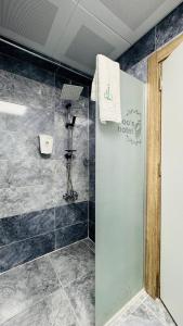uma casa de banho com um chuveiro e uma parede em El Baboos Hotel em Bostaniçi