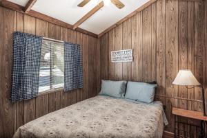 - une chambre avec des murs lambrissés et un lit dans l'établissement Rainbow Lake Cabin & RV Resort, à Ruidoso