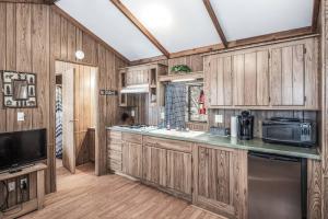 een keuken met houten kasten en een magnetron bij Rainbow Lake Cabin & RV Resort in Ruidoso