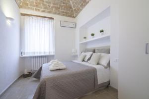 ein Schlafzimmer mit einem Bett mit weißen Kissen und einem Fenster in der Unterkunft Numero 85 in Termoli