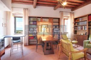 a living room with a table and chairs and bookshelves at Fortezza, vista mare nel centro del borgo medioevale in Castiglione della Pescaia