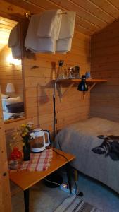 a bedroom with a bed and a table in a room at Lilla Röaby in Bräkne-Hoby