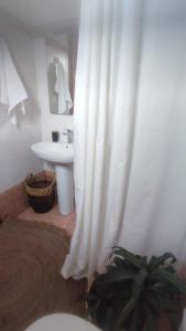 a bathroom with a sink and a white shower curtain at Plakourakia in Finikas