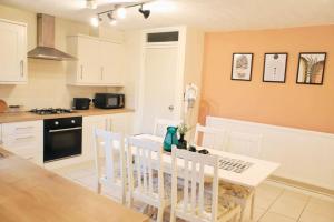 a kitchen with a table and chairs in a kitchen at 20% Monthly stays - 3 bedrooms @ Homevy Leeds in Beeston Hill