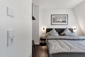 Schlafzimmer mit einem Bett mit weißen Wänden in der Unterkunft Haus Noena in Norderney