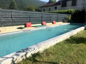 a swimming pool with lounge chairs in a backyard at Maison chez nous in Izeron