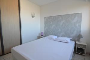 a white bed with two pillows in a bedroom at Appartement vue panoramique avec piscine pour 6 personnes &agrave; Nice quartier Pessicart in Nice