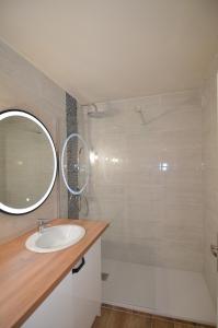 a bathroom with a sink and a tub and a mirror at Appartement vue panoramique avec piscine pour 6 personnes &agrave; Nice quartier Pessicart in Nice