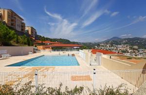 a large swimming pool with a city in the background at Appartement vue panoramique avec piscine pour 6 personnes &agrave; Nice quartier Pessicart in Nice