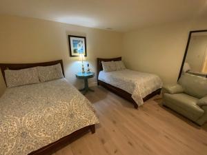 una camera con 2 letti, una sedia e una lampada di Lovely 2-bedroom Suite with lots of Amenities a Traverse City