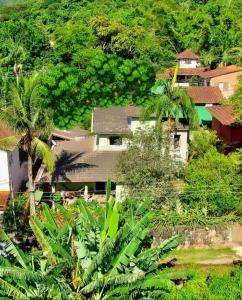 un groupe de maisons sur une colline avec des palmiers dans l'établissement Maresias Home Stay, à São Sebastião