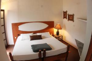 - une chambre avec un lit blanc et une grande tête de lit dans l'établissement Maresias Home Stay, à São Sebastião