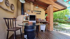 une cuisine avec une table et une cuisinière sur une terrasse dans l'établissement Maresias Home Stay, à São Sebastião
