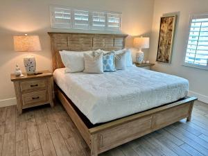 a bedroom with a bed with two night stands and two lamps at Sunshine retreat Elevated New Build walkable to everything including BEACH in Fort Myers Beach