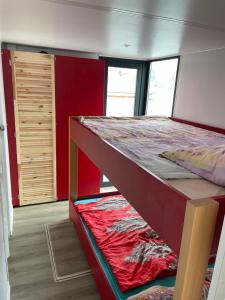 a bunk bed in a room with a red wall at COSY Explorer - führerscheinfrei in Schwerin