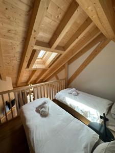 two beds in a room with wooden ceilings at Maison des Sports in Villars-sur-Ollon