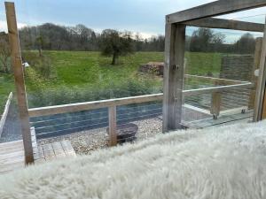 a window with a view of a field with a fence at Guest Homes - The Potting Shed in Worcester