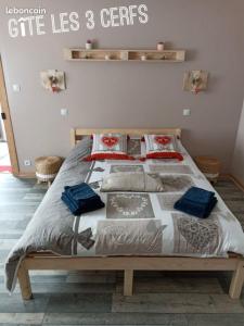 ein Schlafzimmer mit einem Bett mit blauen Kissen darauf in der Unterkunft Gîte Les 3 Cerfs - 3 étoiles in Plainfaing