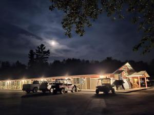 zwei LKWs, die nachts vor einem Gebäude geparkt sind in der Unterkunft Trails INN Quadna Mountain Motel & RV Park in Hill City