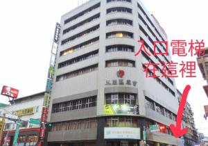 a tall building with a red arrow in front of it at Hey Bear Capsule Hotel in Taipei