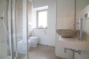 ein Badezimmer mit Waschbecken, Toilette und Spiegel in der Unterkunft Numero 85 in Termoli + 20 Fotos