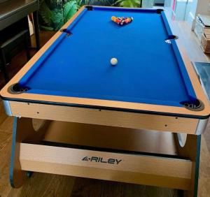 a pool table with a blue cloth on it at Spacious home with free parking in Shirley