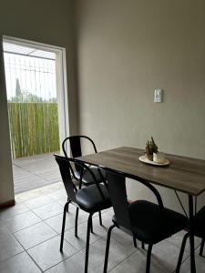 a wooden table and chairs in a room with a patio at Departamento Pergamino Centro in Pergamino