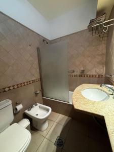 a bathroom with a toilet and a sink at Departamento Pergamino Centro in Pergamino