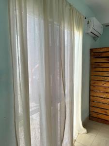 ein Fenster mit weißen Vorhängen in einem Zimmer in der Unterkunft Ahicito - Casa en Tres Cerritos in Salta