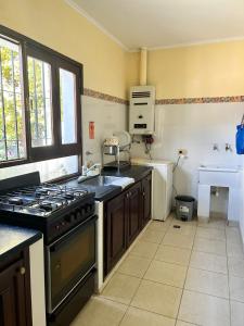 a kitchen with a stove and a sink at Ahicito - Casa en Tres Cerritos in Salta