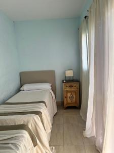 a bedroom with two beds and a table with a window at Ahicito - Casa en Tres Cerritos in Salta +5 photos