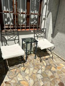 two chairs and a glass table on a balcony at Ahicito - Casa en Tres Cerritos in Salta