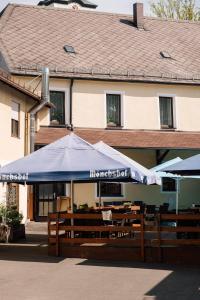 restauracja ze stołami i parasolami przed budynkiem w obiekcie Hotel Weisses Ross w mieście Konnersreuth