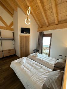 two beds in a room with wooden ceilings at Maison des Sports in Villars-sur-Ollon