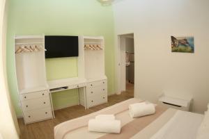 ein weißes Schlafzimmer mit einem TV und einem Bett in der Unterkunft LUCKY LOFT 16 in La Spezia
