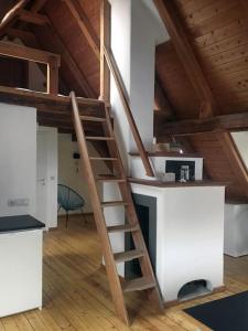 a wooden staircase in a room with a kitchen at Gemütliches Maisonette-Studio in ehemaliger Scheune in Schwäbisch Gmünd