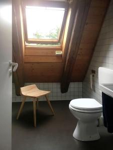 łazienka z toaletą, oknem i stołkiem w obiekcie Gemütliches Maisonette-Studio in ehemaliger Scheune w mieście Schwäbisch Gmünd
