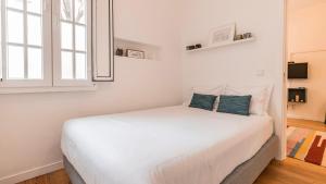 1 dormitorio con 1 cama blanca y 2 almohadas azules en M&M Home by LovelyStay en Lisboa