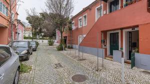 una calle adoquinada con coches estacionados al lado de los edificios en M&M Home by LovelyStay en Lisboa