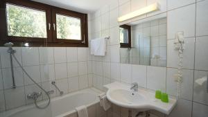 ein Badezimmer mit Badewanne, Waschbecken und Dusche in der Unterkunft Hotel LukasMayr in Bruck an der Großglocknerstraße + 56 Fotos