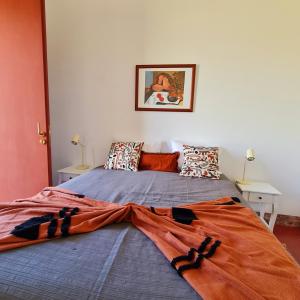 a bedroom with a bed with an orange blanket on it at Monte das Açoteias - Agroturismo in Tavira