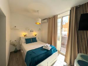 um quarto com uma cama e uma grande janela em Sol de Málaga em Málaga