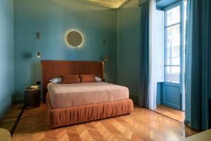 a bedroom with a bed and a large window at Maison Belmonte - Suites in Palermo in Palermo