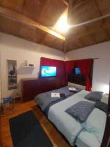 1 dormitorio con 2 camas y TV de pantalla plana en CAMPIÑA SUIZA, en Tabio